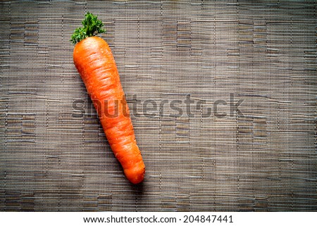 Carrots on brown synthetic fabric background