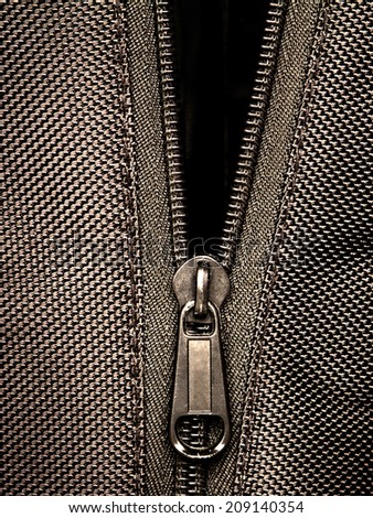 Sepia tone Metal zipper on black synthetic fabric
