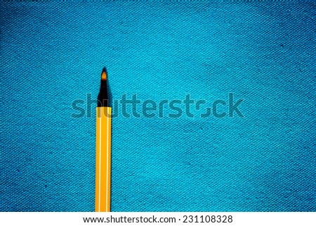 retro color of yellow orange color pen on cyan canvas fabric background
