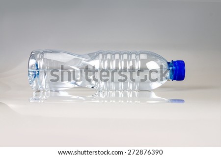 the fresh drink water bottle horizontal placed on abstract grey  background