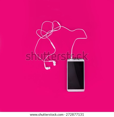 the white earphones for using with digital music or  smart phone on vibrant pink color background