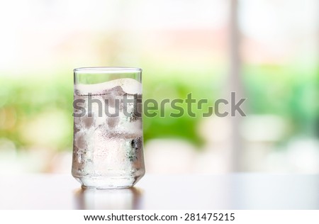 The glass of Cool fresh drink with ice cube on the  table  in living room
