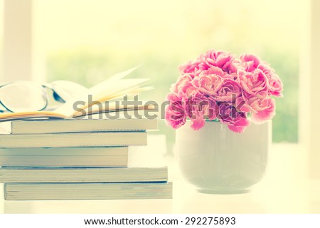 the fresh pink carnation flower with books background