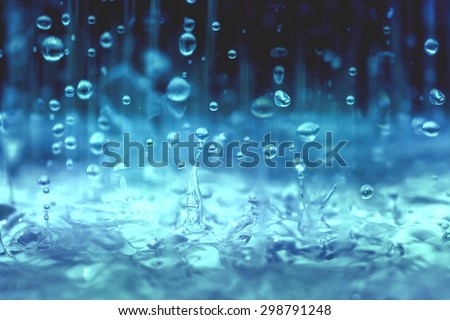 blue color tone of close up rain water drop falling to the floor  in rainy season