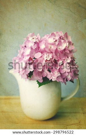 selective focus of the sweet purple  hydrangea flowers in white vase on wooden plate , vintage and still life