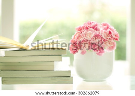 the fresh sweet and romantic pink carnation flower with books background , reading for relaxing and romance moment