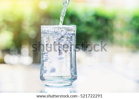 the glass of Cool fresh drink with ice cube and bubble on the  table
