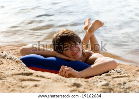 Boy on air-bed at sunny beach