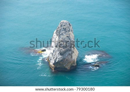 The lonely rock sticks out of water
