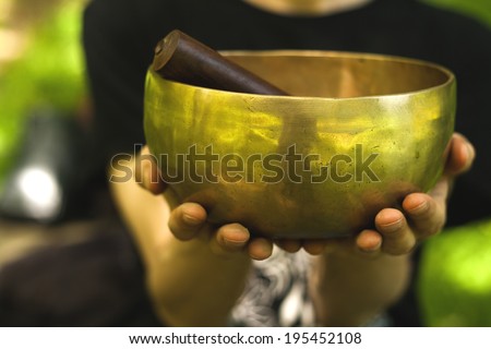 hands holding a tibetan bowl