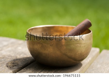 tibetan bowl on wood with green background