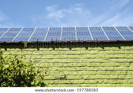 sustainable building, green brickwall with plants and solar panels in the roof