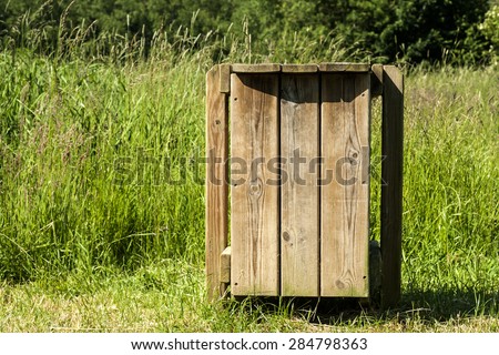 outdoors recycled wood garbage container in a public green area