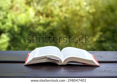 opened book on a garden wooden table