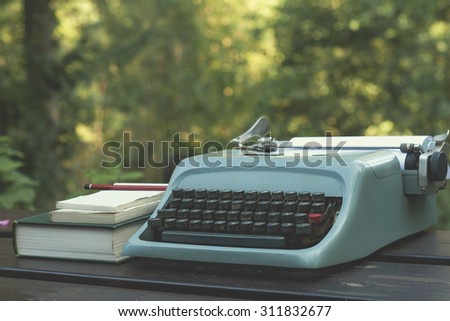 old typewriter on a wooden garden table with books