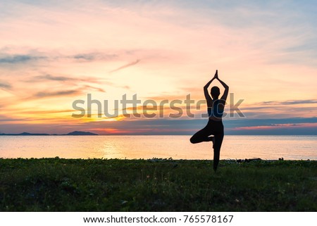 Yoga silhouette. Meditation woman on the ocean during amazing sunset. Fitness and healthy lifestyle.