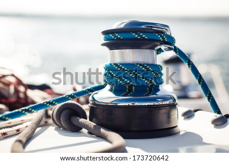 Closeup on yacht cord crank rope holder on white sail background Closeup on yacht cord crank rope holder on white sail background