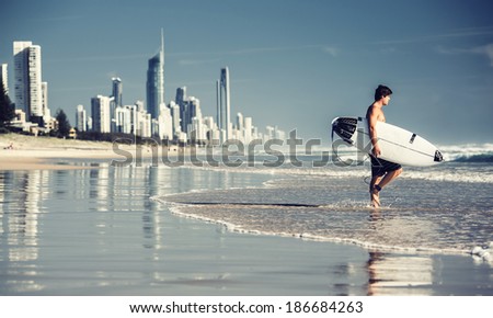 GOLD COAST, AUSTRALIA - JANUARY 2, 2013: Surfer on the beach in City of Gold Coast, Queensland on January 2, 2013, Australia