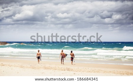 NEW SOUTH WALES, AUSTRALIA - DECEMBER 30, 2012: Surfers goes into the water with surfboards on Byron Bay beach in New South Wales on December 30, 2012, Australia