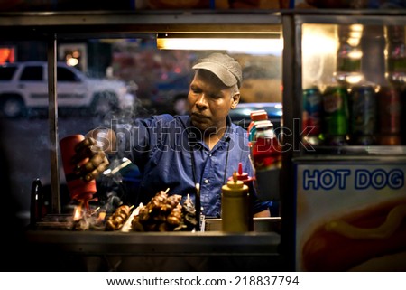 MANHATTAN, NEW YORK - JULY 3, 2011: Male street vendor of hot dogs on the streets of New York on July 3, 2011, Manhattan, USA