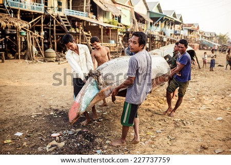 TONLE SAP, CAMBODIA - JANUARY: Unidentified khmer people repair their bot on Tonle Sap lakeo on 01.2014 January. It is the largest lake in Southeast Asia (up to 16,000 square km).