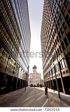 Old russian church between two modern skyscrapers. May be used as contrasts concept.