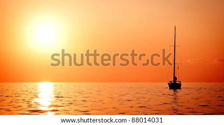 Sailing ship yacht in open sea at sundown