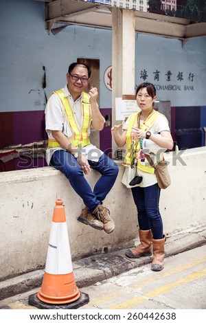HONG KONG, CHINA - MAY 19, 2014: Two parking workers during break at workplace on May 19, 2014