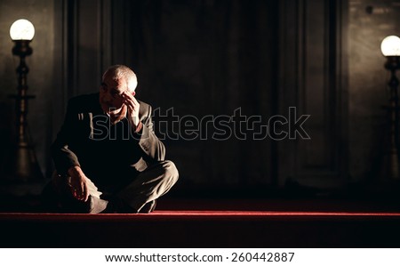 ISTANBUL, TURKEY - NOVEMBER 29: Old man sitting on floor in Mosque, Istanbul, Turkey on November 29, 2014