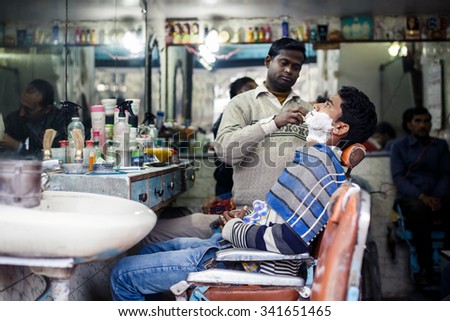 DELHI, INDIA - JANUARY 4, 2015: Barber shaving man on January 4, 2015 in Delhi, India