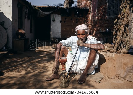 RAJASTHAN, INDIA - JANUARY 9, 2015: Old Indian man smoking hookah on January 9, 2015 in Rajasthan, India