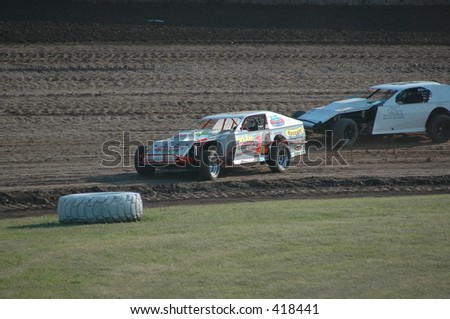 Modified car racing on dirt track.
