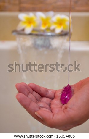 Spa Composition - soap spilling to a hand with waterfall in back