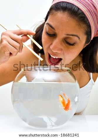 girl catching fish from a bawl