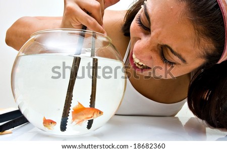 a girl catching fish from a bawl