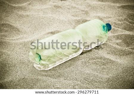 Empty bottle green plastic abandoned on the beach