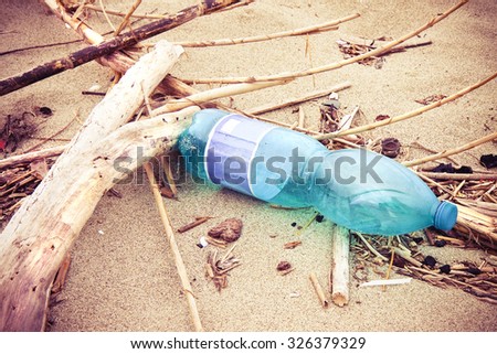 Empty green plastic bottle abandoned on the beach