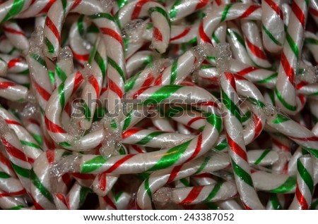 Close up of a bowl of mini candy canes at Christmastime./Small candy canes in a pile