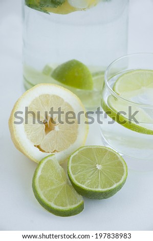 cold cocktail with lemon, lime, decanter with glass on a white background