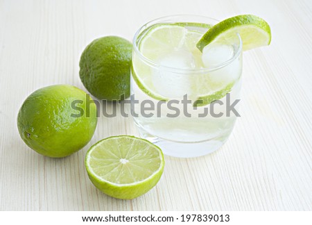 cold cocktail with lime, glass on a white background