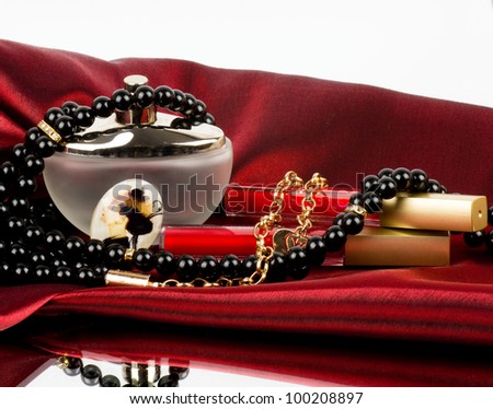 Perfume bottle, red lipstick and pearls beads