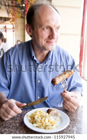 Happy aged man eating restaurant food