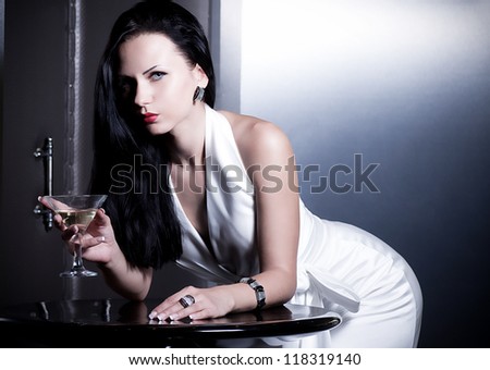Vintage woman in retro dress with martini on dark background