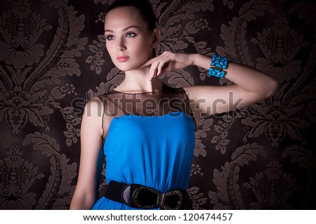 Portrait of beautiful young woman with makeup in blue dress