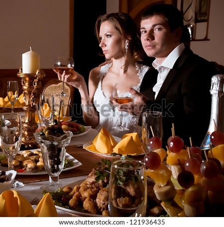 Bride and groom on their wedding day in a luxurious restaurant with banquet