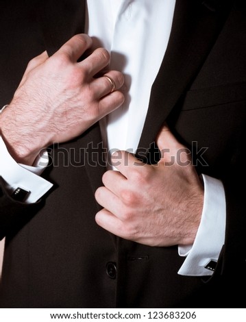 Closeup of a man in black suit with cuff-link