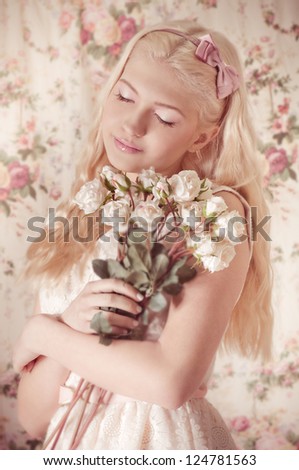 Young girl with bouquet from roses on background.