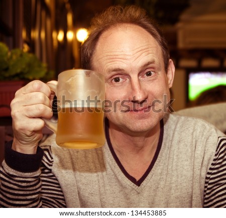 Elderly man holding a beer belly