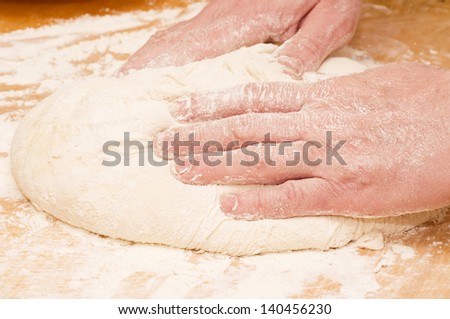 Pair of hands kneading dough