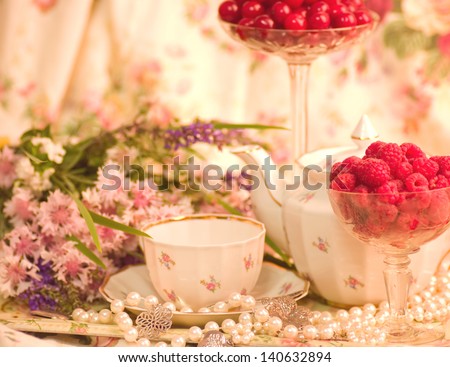 Vintage tea in elegant tableware, raspberry, cherry and flowers